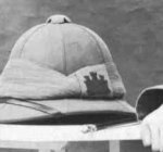 A detail from a 1914 photograph showing a Suffolk Regiment sun-helmet with its castle badge