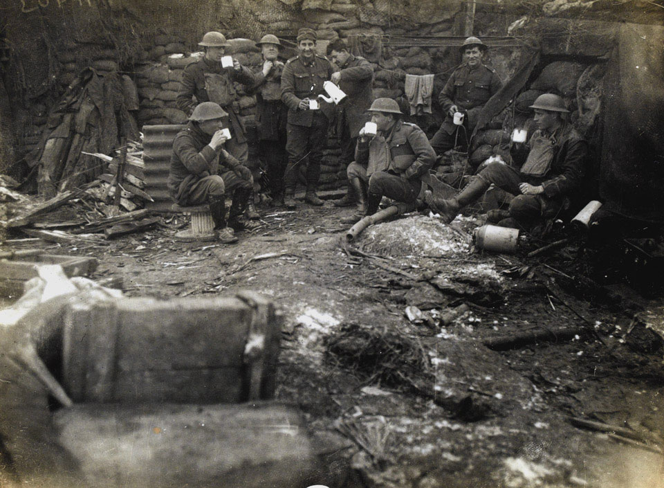 British officers and men enjoy a cup of tea in their trench, 1918
Photograph by Bayley Harrison, World War One, Western Front (1914-1918), 1918.

A mug of hot tea was no doubt welcome during the cold and wet winter months on the Western Front. The presence of an empty rum jar nearby suggests that these soldiers added something stronger to their tea. Army regulations ordered that the rum ration was to be drunk in the presence of an officer or non-commissioned officer so it could not be hoarded.

From a collection of 23 official photographs by press photographer Bayley Harrison.

NAM Accession Number
NAM. 2004-09-3-16

Copyright/Ownership
National Army Museum, Out of Copyright

Location
National Army Museum, Study collection

Object URL
https://collection.nam.ac.uk/detail.php?acc=2004-09-3-16