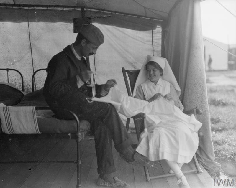 Photograph from IWM online collections: A nursing sister of a Scottish Women's Hospital unit teaches a French patient to sew, Salonika, 1916. (Q 31918)