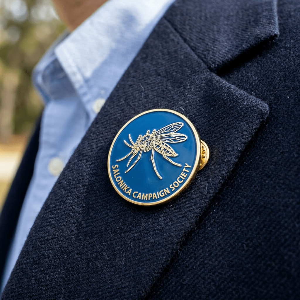 Round lapel pin with a mosquito illustration and the text 'MOSQUITO PATROL' on a navy jacket.